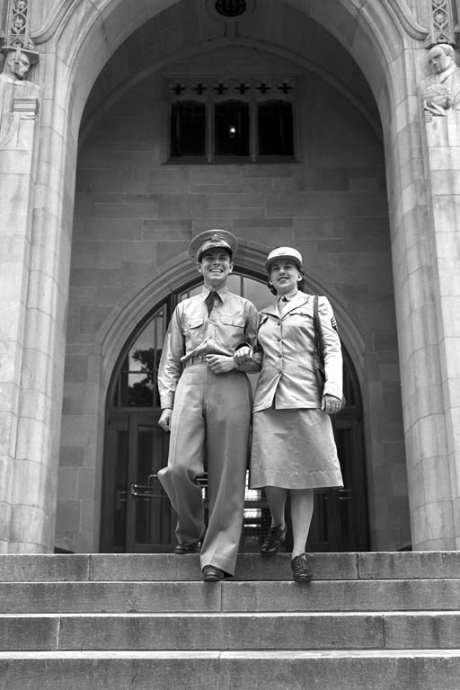 A male and a female student in World War 2 uniform walk down the Indiana Memorial Union stairs