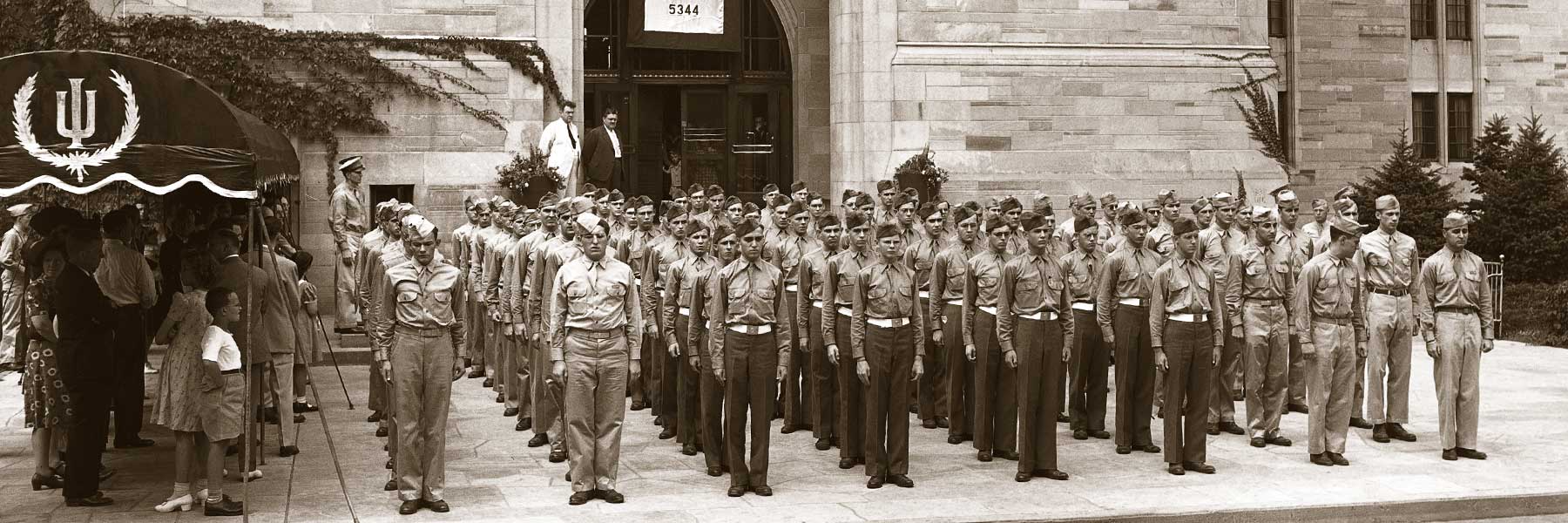U.S. military members stand at attention on the IU campus.