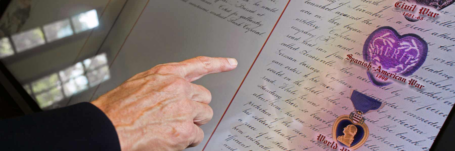 A close up of a hand scanning names in the Golden Book